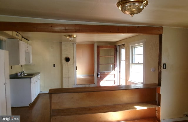 kitchen featuring sink, dark wood-type flooring, white cabinetry, and beamed ceiling