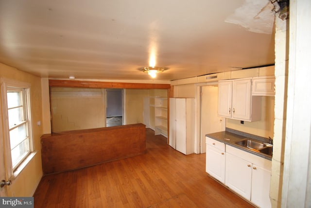 kitchen featuring white cabinetry, sink, and light hardwood / wood-style flooring