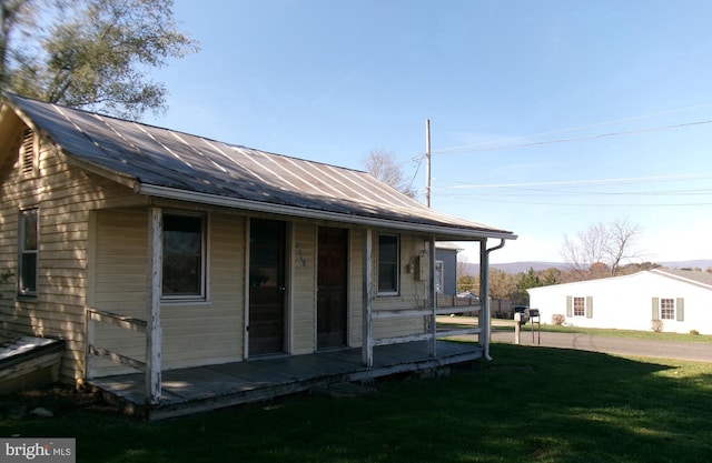 rear view of property featuring a lawn