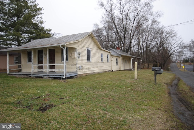 view of property exterior featuring a lawn and covered porch