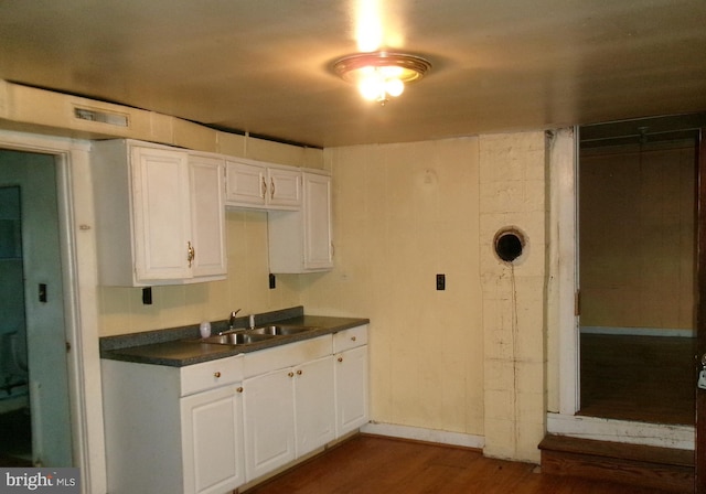 kitchen featuring dark hardwood / wood-style floors, white cabinets, and sink