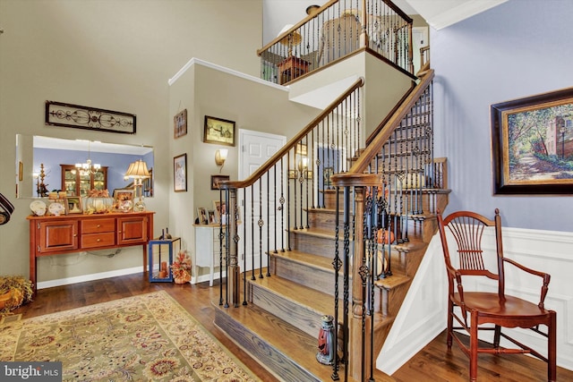 stairs featuring a notable chandelier, dark hardwood / wood-style floors, and a towering ceiling