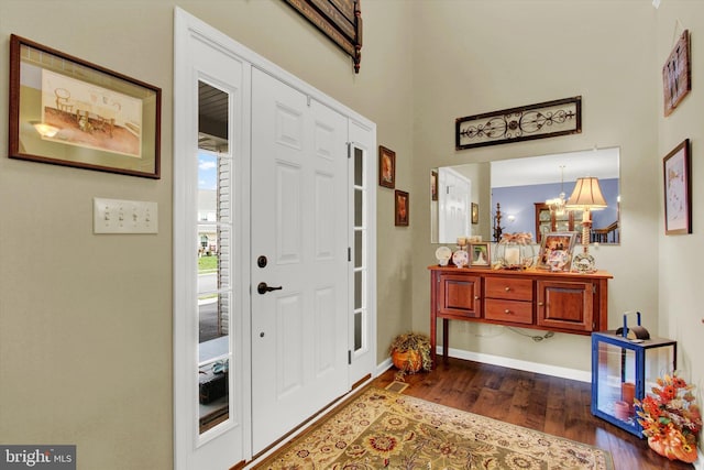 entryway featuring a notable chandelier and dark hardwood / wood-style flooring