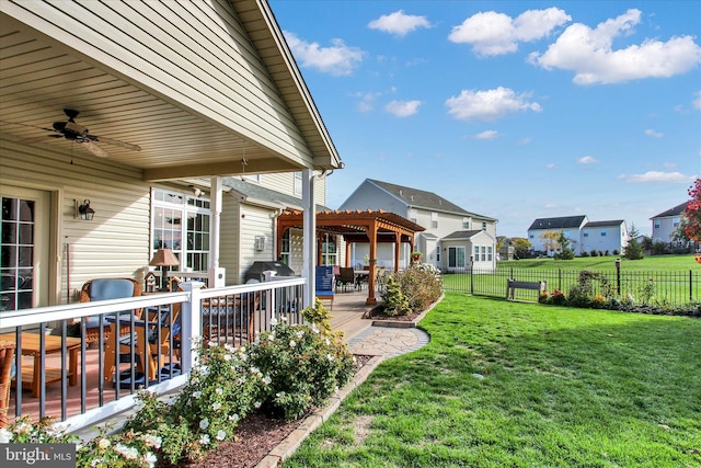 view of yard with a deck and ceiling fan