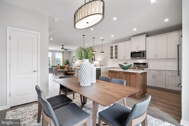 dining room featuring ceiling fan, sink, and dark hardwood / wood-style flooring