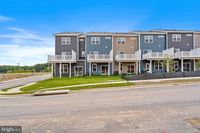 view of front facade with a balcony and a front lawn