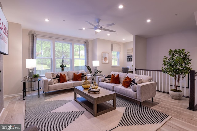 living room featuring ceiling fan and light hardwood / wood-style floors