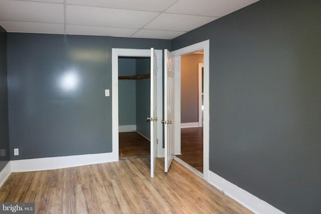 spare room featuring a paneled ceiling and light wood-type flooring