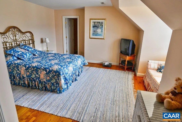 bedroom featuring dark hardwood / wood-style floors and vaulted ceiling