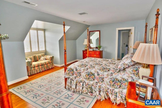 bedroom featuring lofted ceiling and light hardwood / wood-style flooring