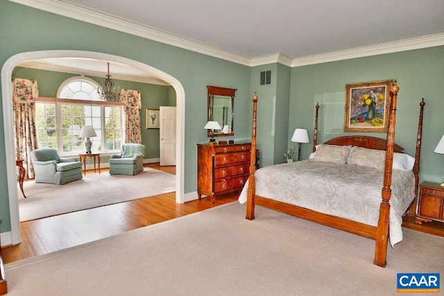 bedroom with an inviting chandelier, ornamental molding, and light hardwood / wood-style flooring