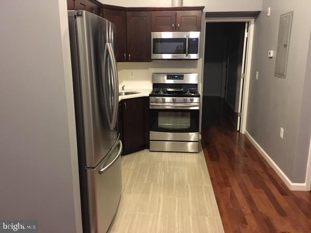 kitchen featuring dark brown cabinets, light hardwood / wood-style flooring, sink, and stainless steel appliances