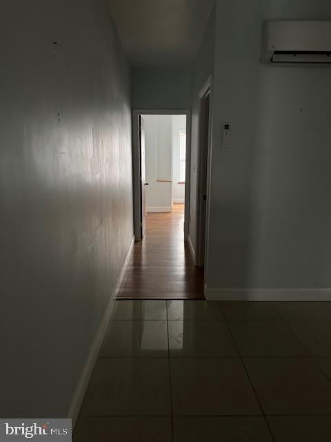 corridor with a wall mounted air conditioner and hardwood / wood-style floors