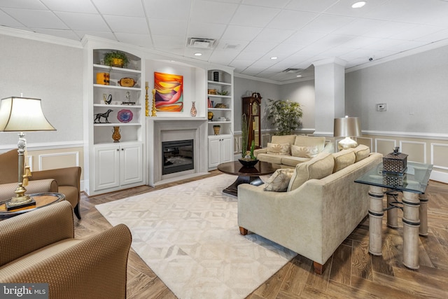 living room featuring crown molding, built in features, and parquet floors