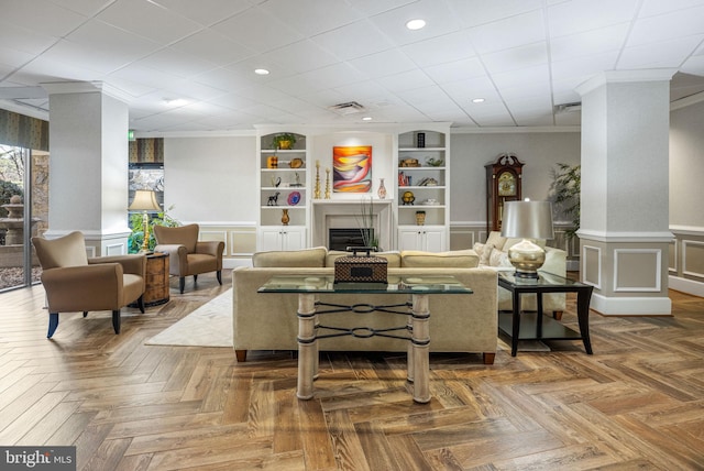 living room with built in features, dark parquet flooring, and crown molding