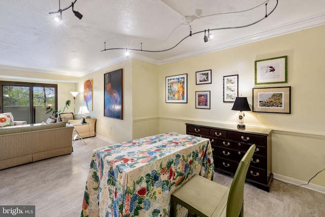 bedroom with a textured ceiling, rail lighting, and crown molding