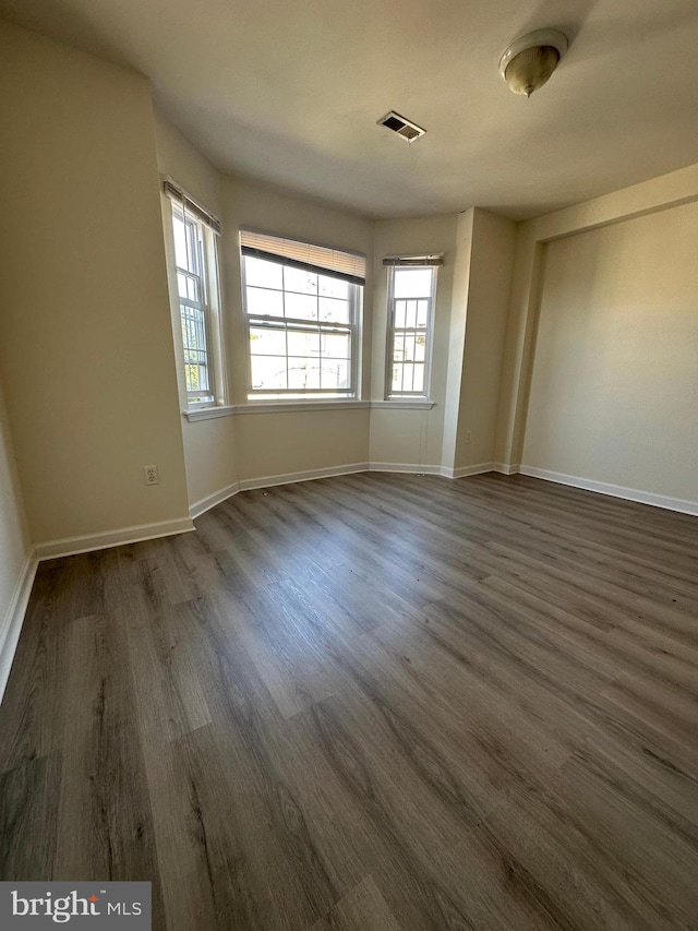 unfurnished room featuring dark wood-type flooring