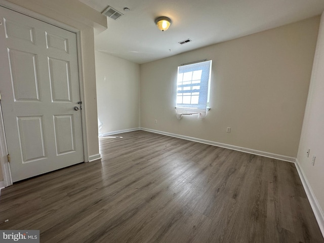 unfurnished room featuring dark wood-type flooring