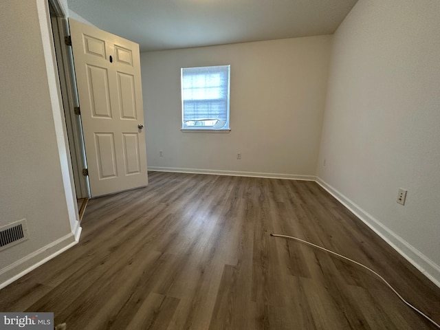 unfurnished room with dark hardwood / wood-style flooring