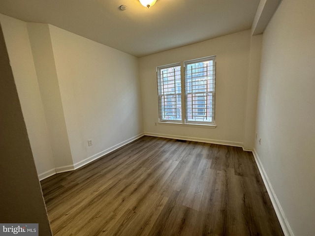 unfurnished room with dark hardwood / wood-style flooring