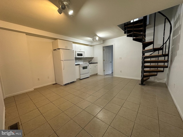 kitchen with white cabinets, light tile floors, and white appliances