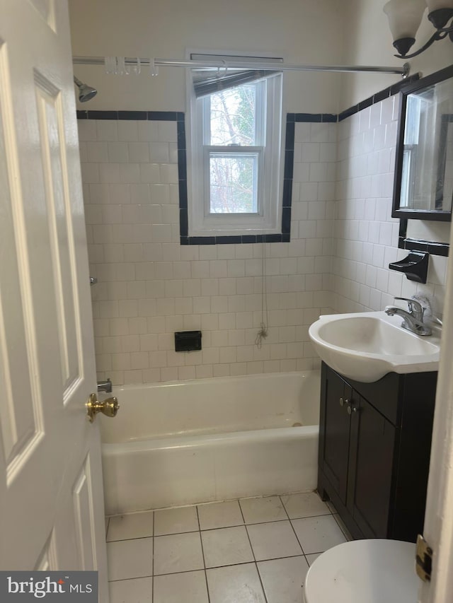 full bathroom with tiled shower / bath combo, toilet, tile floors, and vanity with extensive cabinet space