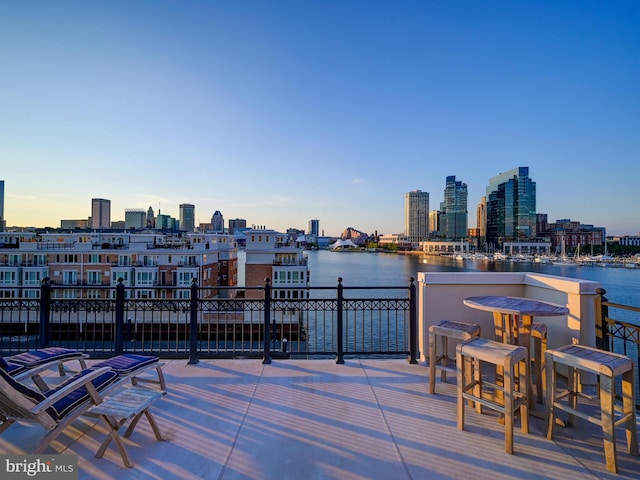 patio terrace at dusk featuring a water view