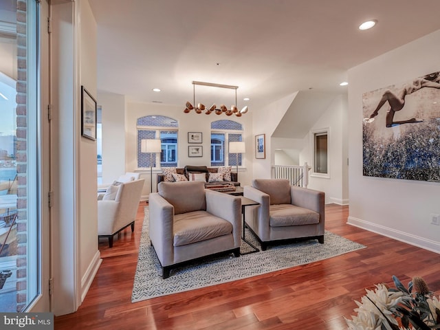 living room featuring a chandelier and dark wood-type flooring