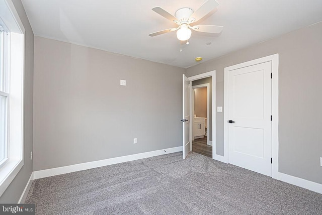 unfurnished bedroom featuring ceiling fan and dark colored carpet