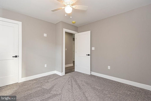 unfurnished bedroom featuring dark carpet and ceiling fan