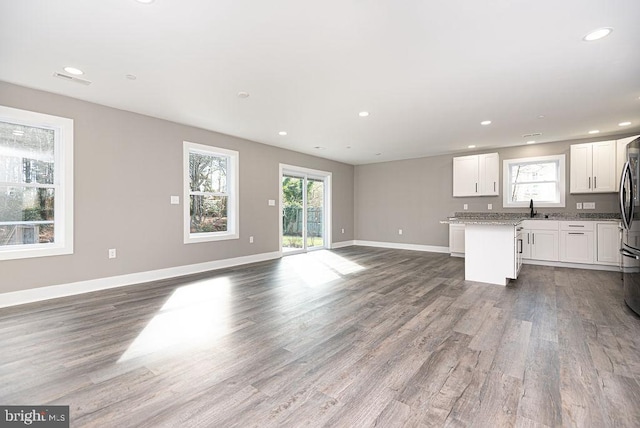 unfurnished living room with dark wood-type flooring and sink