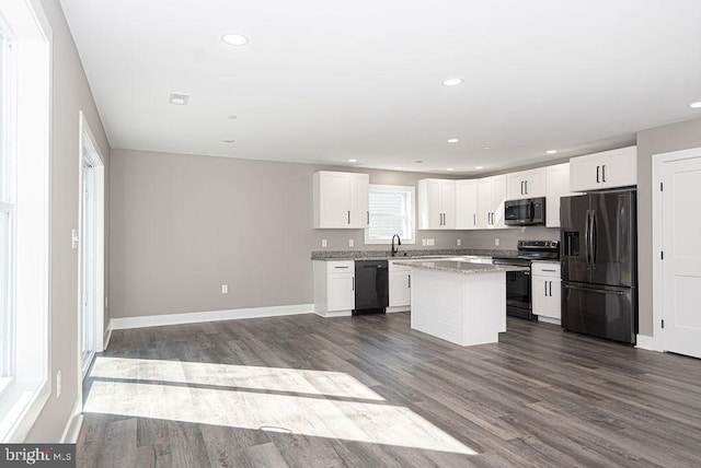 kitchen featuring a kitchen island, dark hardwood / wood-style floors, black appliances, and white cabinetry