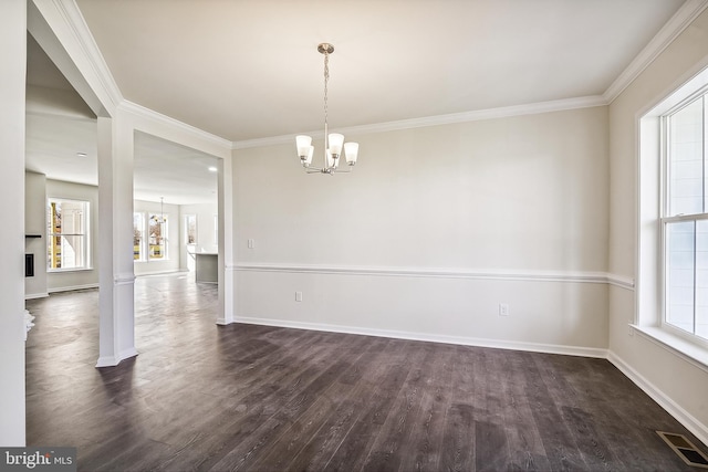 unfurnished room with dark hardwood / wood-style flooring, crown molding, a chandelier, and ornate columns