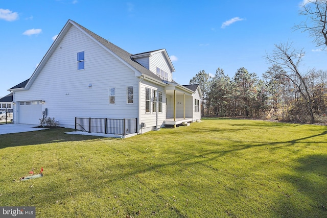 rear view of property featuring a lawn and a garage