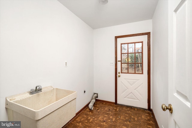 laundry room with electric dryer hookup, sink, and dark parquet flooring