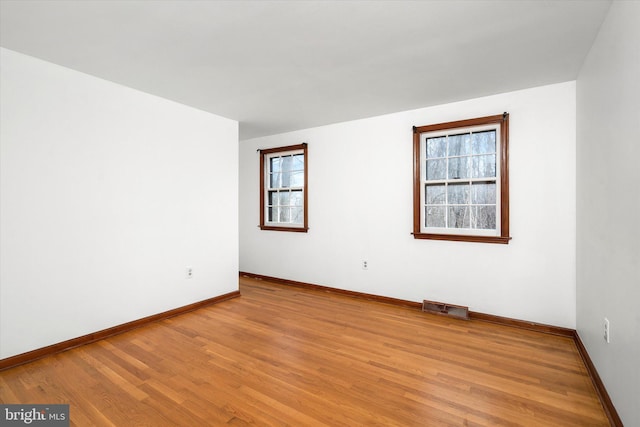 spare room featuring light hardwood / wood-style flooring and a healthy amount of sunlight