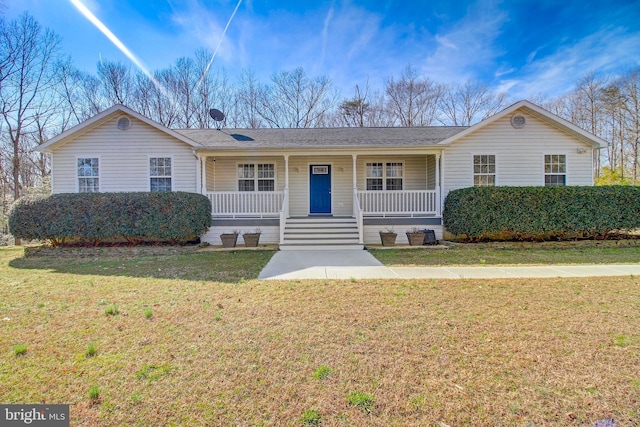 ranch-style house featuring covered porch and a front lawn