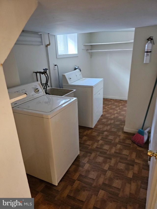 laundry room with independent washer and dryer and dark parquet flooring