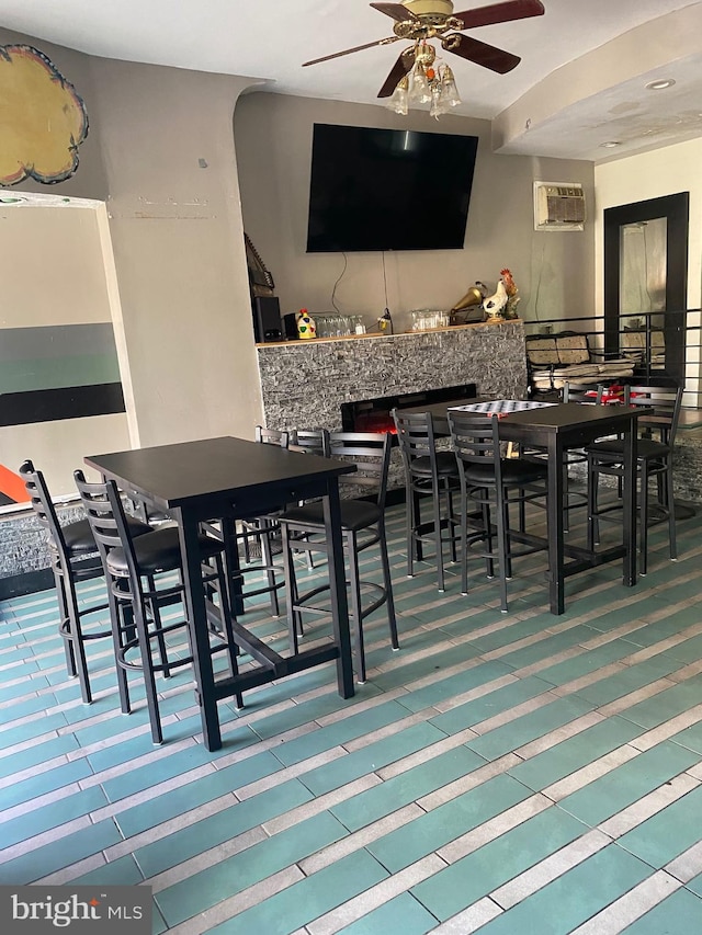 dining space with a wall mounted air conditioner and ceiling fan