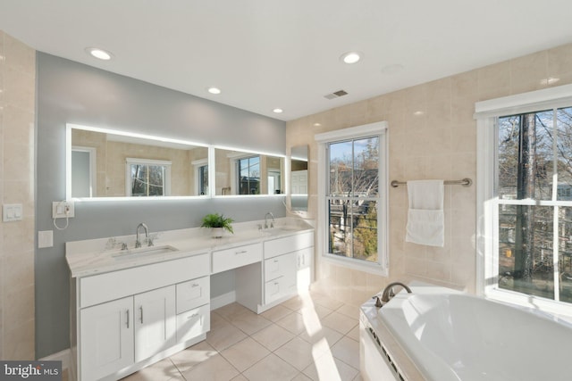 bathroom with vanity, tiled tub, and tile patterned floors