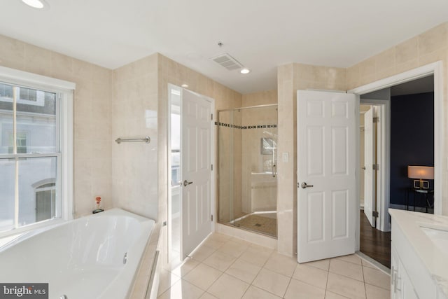 bathroom with shower with separate bathtub, tile walls, tile patterned floors, and vanity