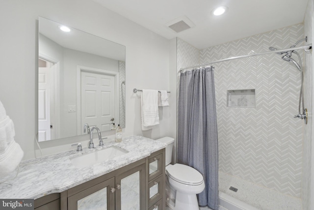 bathroom featuring vanity, walk in shower, and toilet