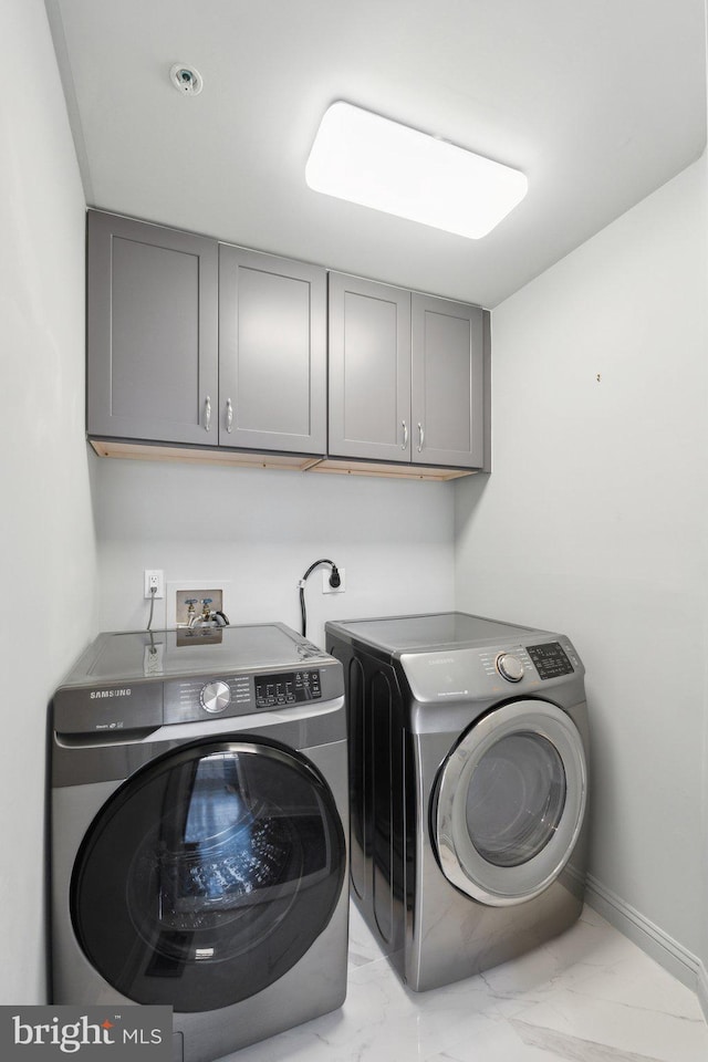 washroom with washer and clothes dryer and cabinets