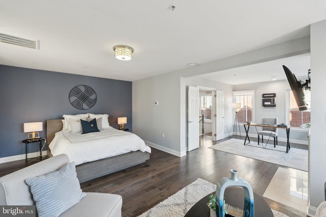 bedroom with dark wood-type flooring and ensuite bath