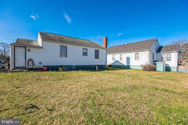 rear view of property featuring a lawn