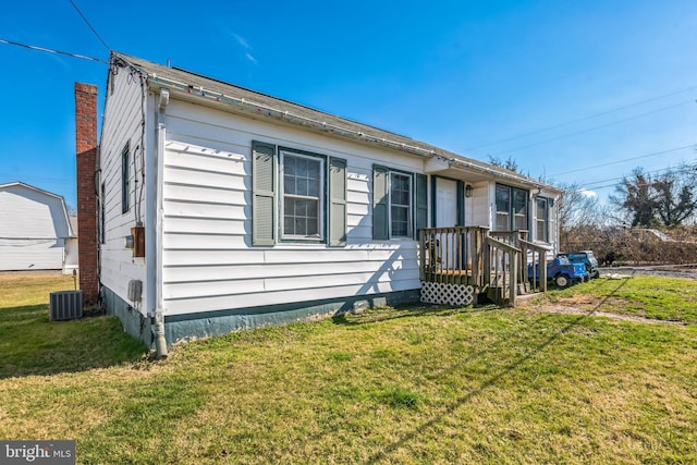 view of front of home with central AC unit and a front lawn