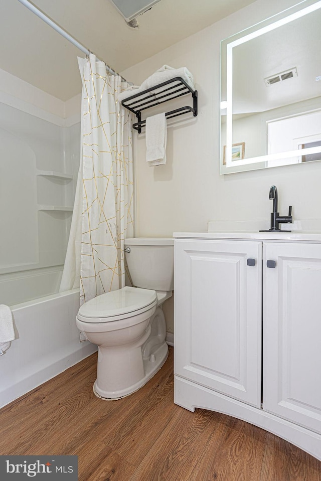 full bathroom featuring vanity, toilet, hardwood / wood-style floors, and shower / bath combo with shower curtain