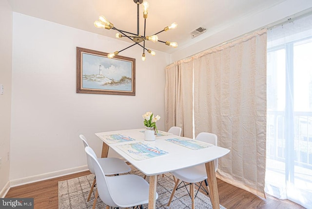 dining area featuring a notable chandelier and wood-type flooring