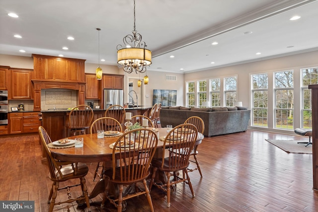 dining space with plenty of natural light, dark hardwood / wood-style floors, and a chandelier