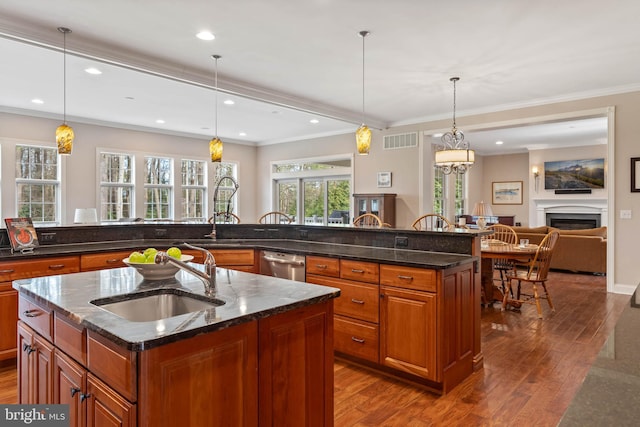 kitchen featuring a center island with sink, hanging light fixtures, and sink